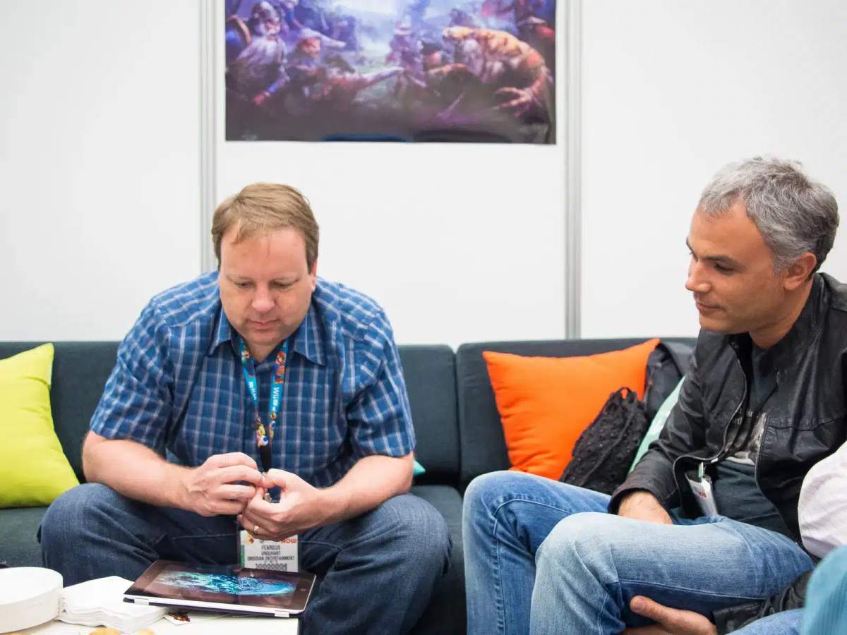 Feargus Urquhart و Sergey Orlovsky يجلسان على أريكة في معرض E3 2013.