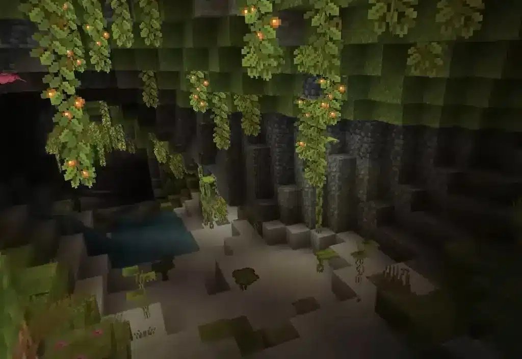 مشهد لمنطقة Lush Caves الحيوية في Minecraft، تظهر فيها ثمار التوهج المتدلية والنباتات الخضراء.